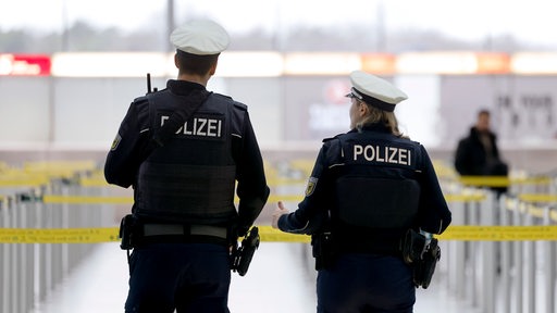 Beamte der Bundespolizei gehen am Flughafen, beide tragen Uniform und Kappe